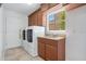 Functional laundry room with new washer and dryer, granite countertop, and ample storage cabinets at 14244 Nottingham Way Cir, Orlando, FL 32828