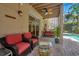 Inviting covered patio with comfortable seating, a ceiling fan, and a view of the screened in pool area at 14244 Nottingham Way Cir, Orlando, FL 32828
