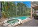 Screened-in pool with a hot tub and patio at 14244 Nottingham Way Cir, Orlando, FL 32828