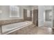 Bathroom featuring a soaking tub, separate glass enclosed shower, and tiled flooring at 14342 Fieldstone Lake Way, Orlando, FL 32824