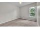 A well lit bedroom with plush carpet, light gray walls, and a large window at 14342 Fieldstone Lake Way, Orlando, FL 32824