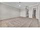 An empty bedroom with soft carpeting and neutral paint with a view to a staircase and another bathroom at 14342 Fieldstone Lake Way, Orlando, FL 32824