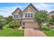 Stunning two-story home featuring stone accents, a brick driveway, and lush landscaping at 14342 Fieldstone Lake Way, Orlando, FL 32824
