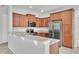 Well-equipped kitchen with wooden cabinets, stainless steel appliances, and granite countertops at 14342 Fieldstone Lake Way, Orlando, FL 32824