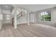 Open living room showcasing a staircase, front door and natural lighting at 14342 Fieldstone Lake Way, Orlando, FL 32824