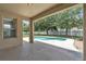Covered patio offering beautiful view of pool and lush green backyard with tall trees at 14342 Fieldstone Lake Way, Orlando, FL 32824