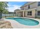 Backyard swimming pool with a concrete surround, next to covered patio and grassy yard at 14342 Fieldstone Lake Way, Orlando, FL 32824