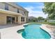 Backyard swimming pool with concrete surround, adjacent to the home and covered patio at 14342 Fieldstone Lake Way, Orlando, FL 32824