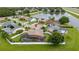 A peaceful neighborhood aerial view featuring a house with a screened pool, positioned near a scenic pond at 1606 Burryport Dr, Orlando, FL 32837