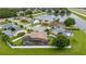 A peaceful neighborhood aerial view featuring a house with a screened pool, positioned near a scenic pond at 1606 Burryport Dr, Orlando, FL 32837