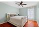 Cozy bedroom featuring hardwood floors, a ceiling fan, and a decorative white bed frame at 1606 Burryport Dr, Orlando, FL 32837