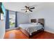 Bedroom offering hardwood floors, a ceiling fan, and a large window with bright blue curtains at 1606 Burryport Dr, Orlando, FL 32837
