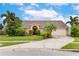 Inviting single-story home featuring a two-car garage, beautifully landscaped yard, and a striking pink exterior at 1606 Burryport Dr, Orlando, FL 32837