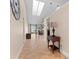 Inviting hallway featuring tile flooring, a decorative table, and a skylight for natural illumination at 1606 Burryport Dr, Orlando, FL 32837