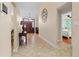 Elegant hallway featuring tile flooring, a dark wood table, a striking clock, and views into other rooms at 1606 Burryport Dr, Orlando, FL 32837