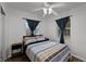 Bedroom featuring a ceiling fan, two windows, wood floors, and an accent wall at 1649 Weybridge St, Deltona, FL 32725