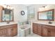 Bright bathroom features double sink vanities and a relaxing soaking tub beneath a window at 165 Fig Tree Run, Longwood, FL 32750