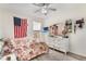 Cozy bedroom features a floral bedspread, whitewashed dresser, and ceiling fan for added comfort at 165 Fig Tree Run, Longwood, FL 32750