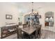 Dining room with an elegant chandelier, gray wood floors, and ample natural light; open concept at 165 Fig Tree Run, Longwood, FL 32750