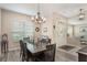 Dining room with modern chandelier and neutral tones with wood-look flooring, and bright front door at 165 Fig Tree Run, Longwood, FL 32750