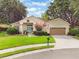 Charming single-story home with a well-manicured lawn, mature trees, and a lovely blue front door at 165 Fig Tree Run, Longwood, FL 32750