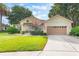 Charming home with a manicured lawn, mature trees, and a welcoming entrance at 165 Fig Tree Run, Longwood, FL 32750