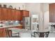 Kitchen featuring granite counters, stainless appliances, wood cabinets, and bar seating at 165 Fig Tree Run, Longwood, FL 32750