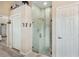 Neutral bathroom features a modern tiled shower with glass enclosure and a convenient storage closet at 165 Fig Tree Run, Longwood, FL 32750