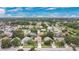 An aerial view shows a neighborhood with mature trees and well-maintained homes at 1916 Excalibur Dr, Orlando, FL 32822