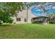 This backyard has a covered screened patio, a grill, and healthy green grass at 1916 Excalibur Dr, Orlando, FL 32822
