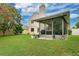 The backyard includes a covered, screened in patio, a grill, and a manicured lawn at 1916 Excalibur Dr, Orlando, FL 32822