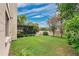 This backyard offers a covered patio, a manicured lawn, and privacy fencing at 1916 Excalibur Dr, Orlando, FL 32822