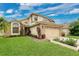 Charming two-story home boasts a well-manicured lawn, brick facade and attached two-car garage at 1916 Excalibur Dr, Orlando, FL 32822