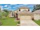 Charming two-story home features a brick facade, well-manicured lawn, and attached two car garage at 1916 Excalibur Dr, Orlando, FL 32822