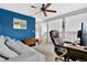 This home office includes a ceiling fan, desk, comfortable chair, and bonus couch at 1916 Excalibur Dr, Orlando, FL 32822