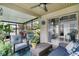 This cozy patio includes comfortable chairs, a ceiling fan, and direct access to the backyard at 1916 Excalibur Dr, Orlando, FL 32822