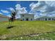 View of the back exterior of the home with large lawn at 228 Aquamarine Ln, Kissimmee, FL 34758