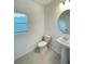 Bathroom featuring a pedestal sink, a toilet, a mirror, and a window with blinds at 228 Aquamarine Ln, Kissimmee, FL 34758