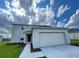 Two story home featuring a two-car garage, neutral paint scheme, and manicured landscaping at 228 Aquamarine Ln, Kissimmee, FL 34758