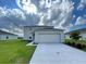 Two story home featuring a two-car garage, neutral paint scheme, and freshly cut lawn at 228 Aquamarine Ln, Kissimmee, FL 34758