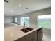Modern kitchen featuring an island with sink, stainless steel appliances, and tile flooring at 228 Aquamarine Ln, Kissimmee, FL 34758