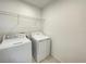 Laundry room features a washing machine, dryer, and wire shelving for storage and organization at 228 Aquamarine Ln, Kissimmee, FL 34758