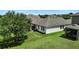 Aerial view of the home with a well-maintained lawn, patio and mature trees at 2718 Limerick Cir, Grand Island, FL 32735