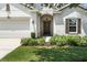 Close-up of the front door, garage, and landscaping, highlighting the home's curb appeal at 2718 Limerick Cir, Grand Island, FL 32735
