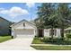 Charming single-story home featuring a two-car garage, neutral paint, and well-manicured landscaping at 2718 Limerick Cir, Grand Island, FL 32735