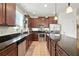 Well-lit kitchen with dark cabinets, granite countertops, and stainless steel appliances at 2718 Limerick Cir, Grand Island, FL 32735