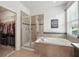 Main bathroom features a soaking tub, a separate shower with glass doors, and a walk-in closet at 2718 Limerick Cir, Grand Island, FL 32735