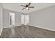 A spacious bedroom featuring wood floors, ceiling fan, and doorways leading to a closet and bathroom at 2739 N Poinciana Blvd # 77, Kissimmee, FL 34746