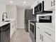 Updated kitchen featuring white cabinets, granite countertops, and stainless steel appliances at 2739 N Poinciana Blvd # 77, Kissimmee, FL 34746