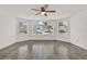 This living room features a ceiling fan, large windows, and stylish gray wood flooring at 2739 N Poinciana Blvd # 77, Kissimmee, FL 34746